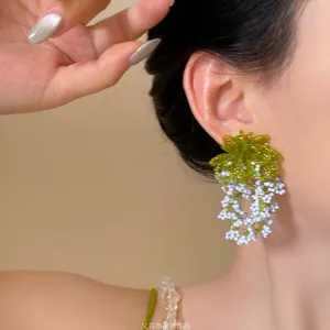 Close-up of handmade lily of the valley earrings with green and white crystal beads