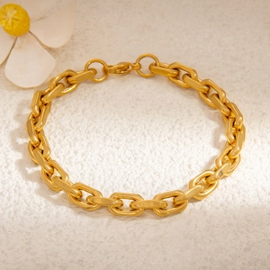 Detail of 18k gold plated chunky chain bracelet with lobster clasp on white sand