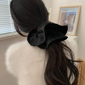 Premium black satin oversized scrunchie hair tie shown in a low ponytail styling