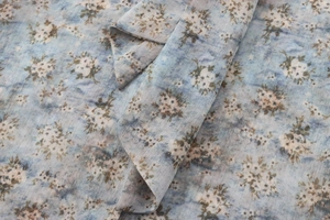 Gros plan sur le tissu en popeline bleu clair avec motifs floraux et texture douce