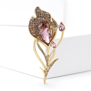 Macro detail of high-end floral brooch featuring pink pear-shaped crystal and rhinestones