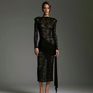Detail of elegant black lace patchwork dress with flowing ribbons and slim silhouette