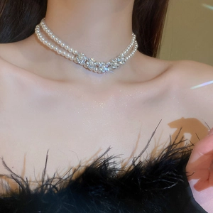 Close-up of double-layer choker with pearls and rhinestone flowers on a woman's neck