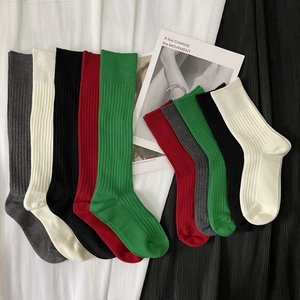 Vertical rib knit calf socks in vibrant colors including green, black and red tones