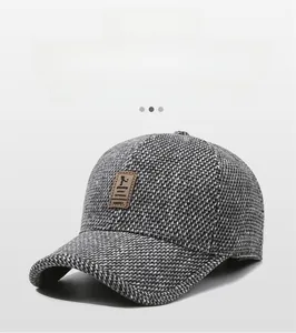 Close-up of thick winter baseball cap with tweed fabric texture and brown leather patch