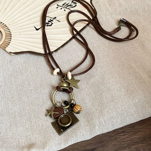 Macro detail of vintage necklace with bronze pendants and beads on rustic linen