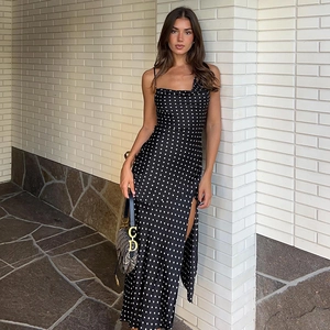 Polka dot spaghetti strap dress with cowl neck and side slit shown on model in sunlight