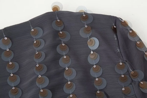 Detailed macro view of gray sequin fabric with vertical brown and silver bead patterns