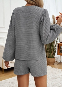 Vista posteriore di un set in maglia da donna con maglione e pantaloncini a scacchi bianchi e neri