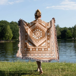 Outdoor view of a large bohemian woven blanket with geometric patterns and fringe