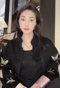 Gros plan de broderies papillon dorées sur une veste noire avec doublure en satin rose