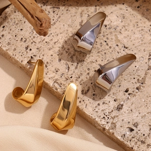 Polished hollow geometric earrings in gold and silver finish on textured stone
