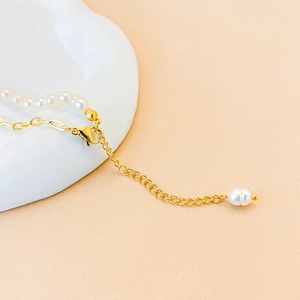 Detail of freshwater pearl necklace featuring gold lobster clasp and teardrop pearl extension