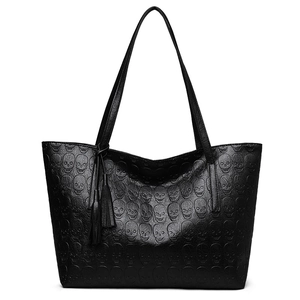 Minimalist black tote bag with skull pattern texture and leather tassel detail
