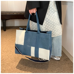 Detail of blue and white patchwork denim tote bag showing sturdy straps and large capacity