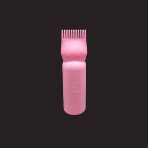 Pink hair dye squeeze bottle detail with comb nozzle and molded scale markings