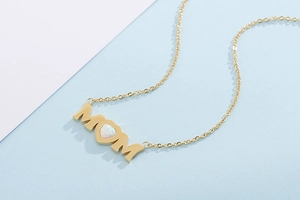 Detailed view of gold MOM letter necklace with heart-shaped opal stone inlay