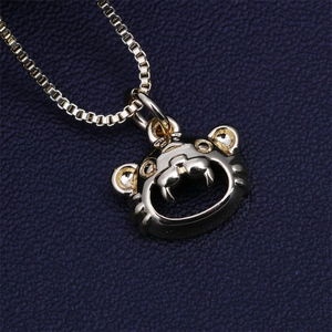 Close-up of polished gold tiger pendant necklace on a dark blue textured backdrop