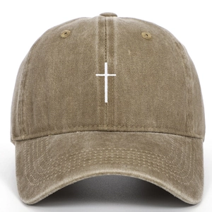 Detail der weißen Kreuzbestickung auf khakifarbener verwaschener Vintage-Cap