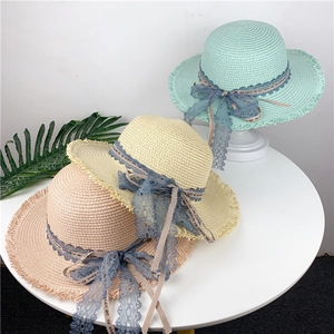 Detailed view of woven straw sun hats with lace bows in pink, beige, and mint colors