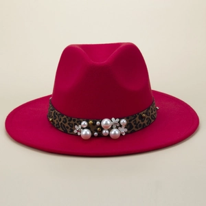 Détail d'un chapeau fedora rose fuchsia avec ruban léopard et fleurs de perles
