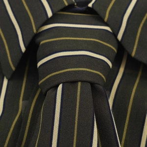 Detailed close-up of striped tie in olive green and navy with woven texture