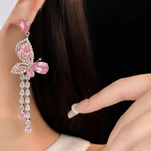 Detail of butterfly drop earrings featuring pink zircon teardrops and silver tassels