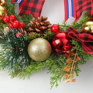 Christmas wreath featuring pine cones, festive ornaments and a red plaid bow decoration