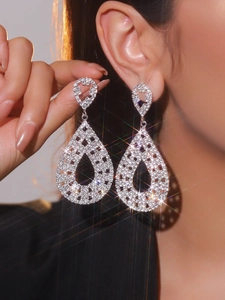 Detailed view of elegant silver teardrop earrings with shimmering rhinestones on a model