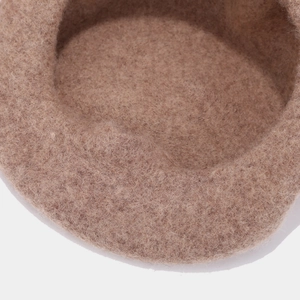 Close-up of thick wool felt texture on a brown retro beret with soft fiber details