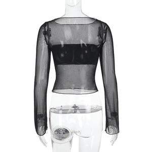 Détail du tissu en maille noire transparente sur un haut court à manches longues