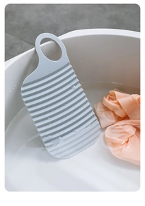 Detail of light blue handheld washboard with wave anti-slip texture and hanging hole
