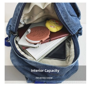 Interior view showing the large storage capacity for tablets and books in denim backpack