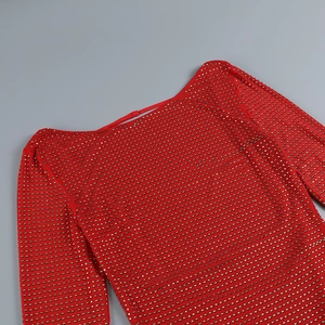 Detailed close-up of red bodycon dress with gold rhinestones and stud embellishments