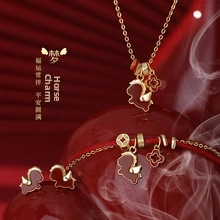 Macro detail of red enamel horse and clover jewelry set in gold-plated sterling silver