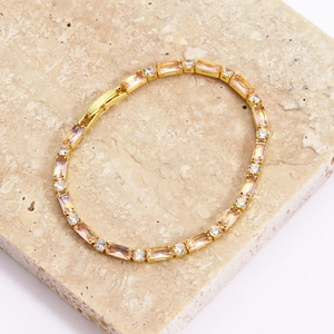 Dettaglio del bracciale dorato con pietre rosa rettangolari e zirconi cubici trasparenti