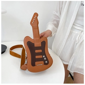 Detail view of guitar shaped crossbody bag with brown leather and silver star rivets