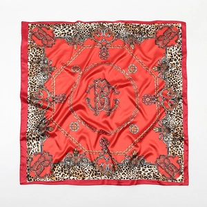 Detail of red satin scarf featuring leopard print borders and gold baroque chain patterns