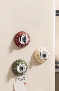 Mechanical magnetic kitchen timer showing red, green, and beige colors on metallic surface