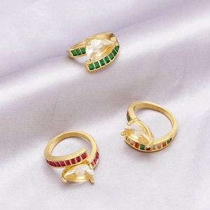 Detail view of gold-plated rings with pear-cut gemstones in green, red, and multicolor