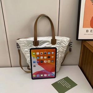 Weiße gesteppte Tragetasche mit braunen Griffen und einem iPad zum Größenvergleich