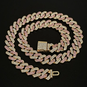 Macro detail of 14mm Cuban link chain with pink and white rhinestones on gold base