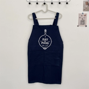 Detail of navy blue cotton apron with white frying pan print and two front pockets