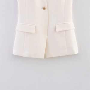 Sleeveless white halter vest top featuring a textured gold button and flap pockets