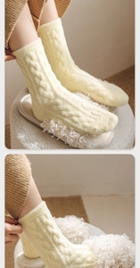 Detail of warm yellow cable knit winter socks paired with plush white slippers