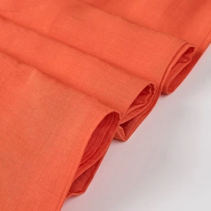 Vue macro détaillée du tissu textile orange vif avec texture de tissage claire et toucher doux