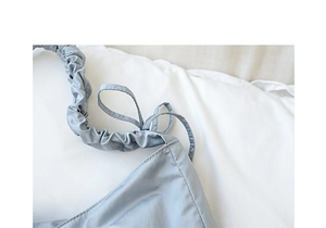 Detail of blue-grey nylon shoulder bag featuring ruched straps and drawstring closure