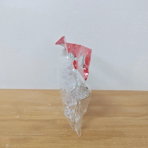 Transparent acrylic angel ornaments in packaging with festive red header card on wood
