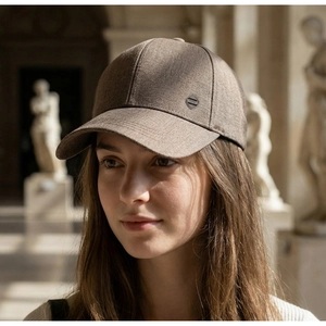 Détail d'une casquette de baseball marron pour homme avec logo métallique sur le côté