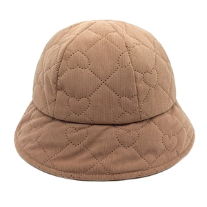 Detail of brown corduroy bucket hat featuring heart-shaped diamond quilting pattern